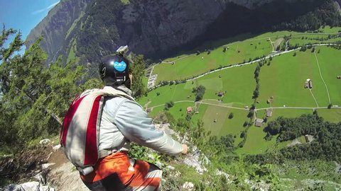 A base jumper jumping from a cliff