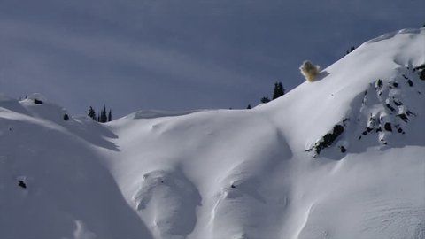 An explosive starts an avalanche in beautiful winter landscape