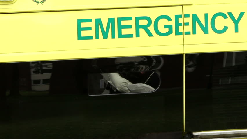 Look inside the ambulance through the open window with a big sign EMERGENCY over the window - UK. Nurse filling form. Royalty-Free Stock Footage #7101991