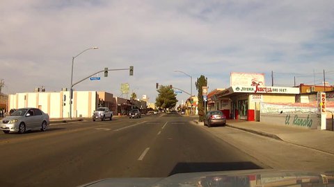BARSTOW, CA: July 21, 2014- Point of view POV shot of a car driving in downtown circa 2014 in Barstow. A vehicle travels through a small town's business district route off of the major highway.