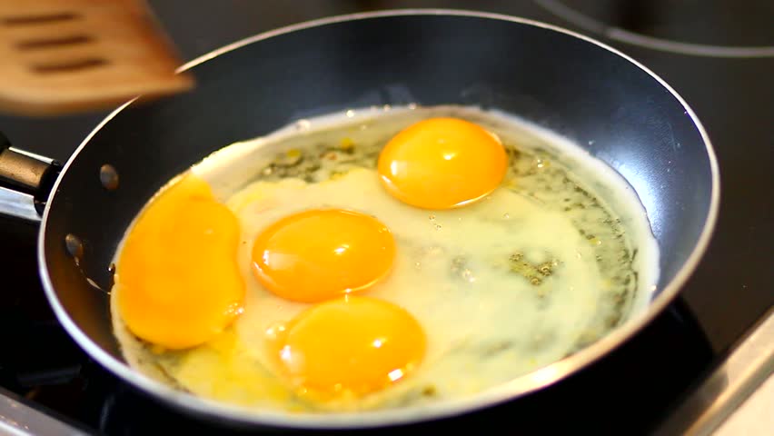 Preparing scrambled eggs on hot frying pan