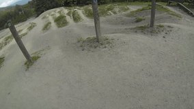 1080p wide angle video of a mountain biker riding over small jumps at the bike skills park on a sunny day. Shot with a helmet mounted action camera at 60fps, perfect for slow motion edits.