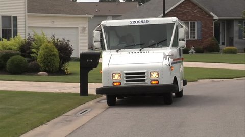 CIRCA 2010s - U.S. Postal vehicles deliver mail in suburban neighborhoods.