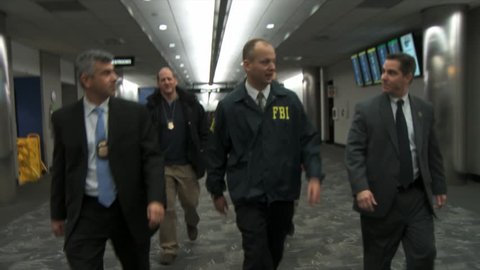 CIRCA 2010s - FBI agents and Homeland Security walk through an airport.
