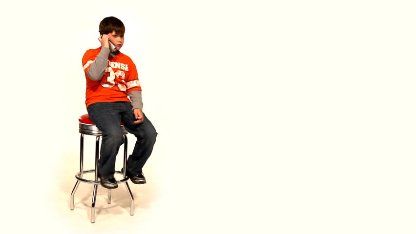 A young boy talks on a cordless telephone.