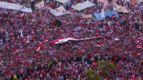 CAIRO, EGYPT - CIRCA 2013 - Overhead view as protestors wave flags and jam Tahrir Square in Cairo, Egypt.