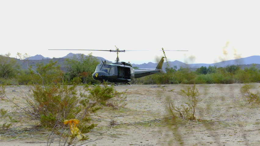 A series of focus racks and snap zooms of a Huey helicopter in the desert.