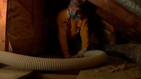CIRCA 2010s - Construction workers pump insulation into an attic to weatherize a home.