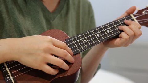 footage of woman playing ukulele