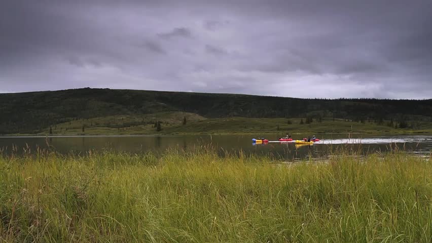 Rafters paddling on Wonder Lake in Denali National Park with approaching storm