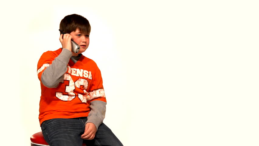 A young boy talks on a cordless telephone.