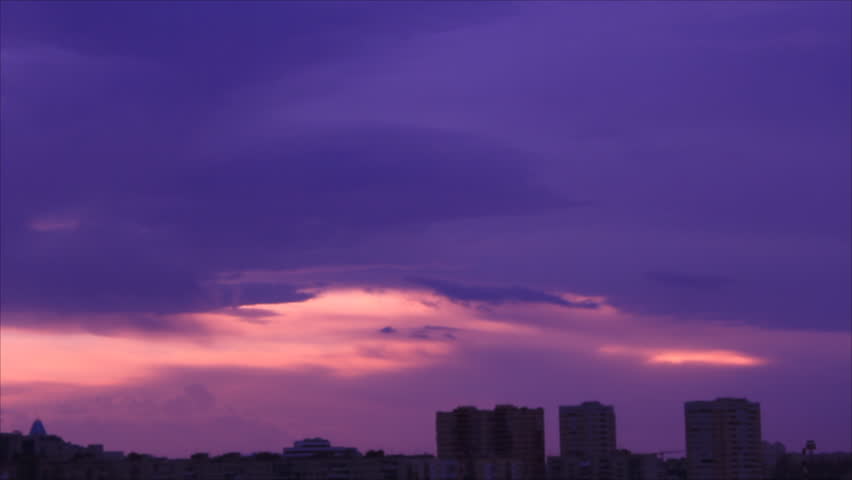 Town buildings silhouette under purple twilight sky