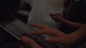 Girl opens an airplane window and  looks out during air travel. Smiling. Happy. Young women traveling by plane together. Tourism concept. Slow motion 240 fps Full HD 1920x1080p. High speed camera shot