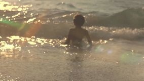 A little Child runs out of the sea A Little funny Happy Girl Having Fun in the Sea Water Enjoying by Waves Baby Splashes in the Wave on the Summer Beach. Slowmotion video footage 240 fps full HD 1080p