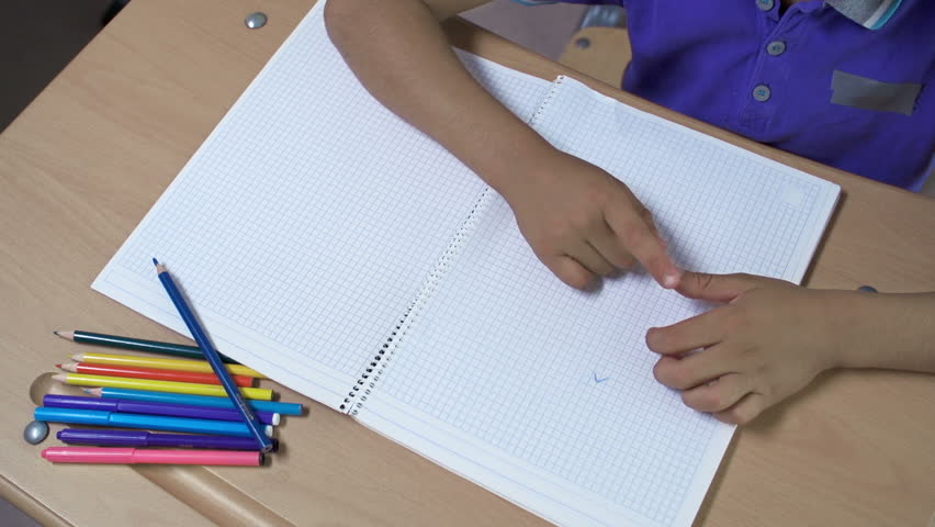 Overhead shot of boy drawing in notebook