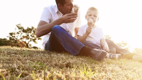 Father and son eating ice cream, steadicam shot. Arkistovideo