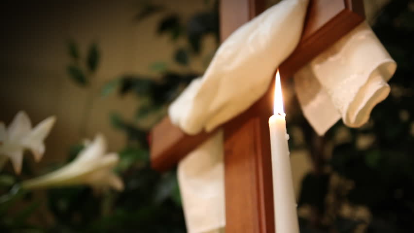 A candle near a cross in church at Easter.
