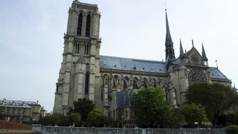 Looking up to the towers of the Notre Dame while people walk past