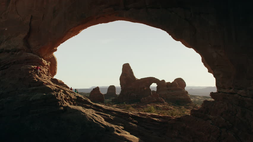 Wide time lapse shot of hikers at national park arch / Arches National Park, Utah, United States