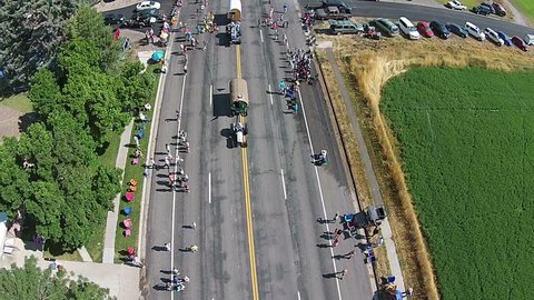 FOUNTAIN GREEN, UTAH - JUL 2014: Aerial sheep farmers driving camp wagons in parade. Small rural community annual celebration, family reunion festival. Homemade floats, tractors, high school bands.