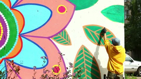 Modern urban art - man drawing with spray on wall