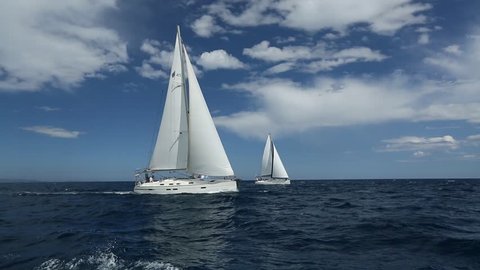 Sailboats participate in sailing regatta. Sailing in the wind through the waves. Luxury Yachts.