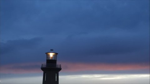 lighthouse at sunset with rotating beam
