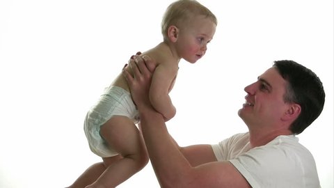 Father holding baby in the air and making him giggle, isolated on white.