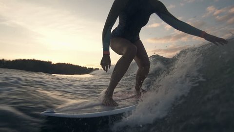 Slow motion of sportive lady surfing in the twilight