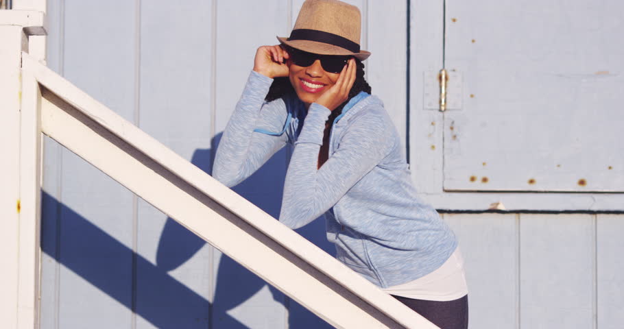 Happy Black woman leaning on wooden rail