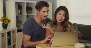 Mixed Race couple chatting with friends on laptop