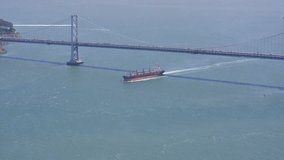 Aerial shot of container ship entering San Francisco Bay under the Bay Bridge