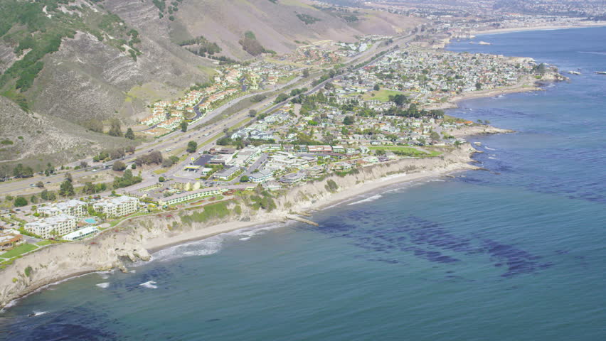 Aerial view of California Coastline along the Big Sur. USA homes & hotels line the cliffs overlooking the blue ocean.