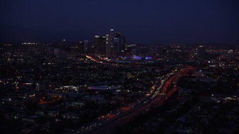 Aerial view of Los Angeles, California at night. Helicopter shot over homes and business buildings in American suburbs.