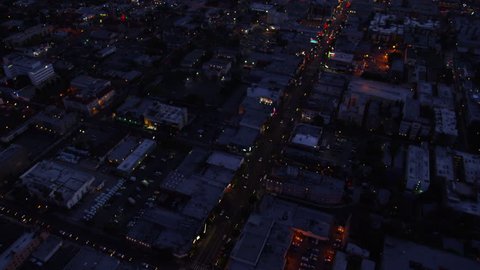 Aerial view of Los Angeles, California at night. Helicopter shot over homes and business buildings in American suburbs.