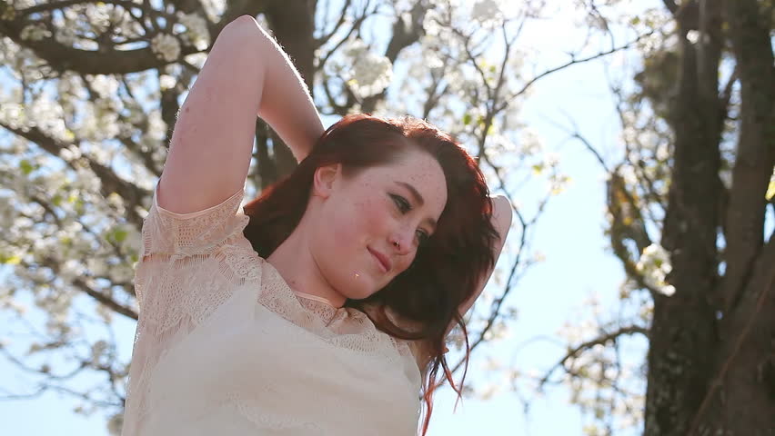Beautiful Redhead smiles in a park