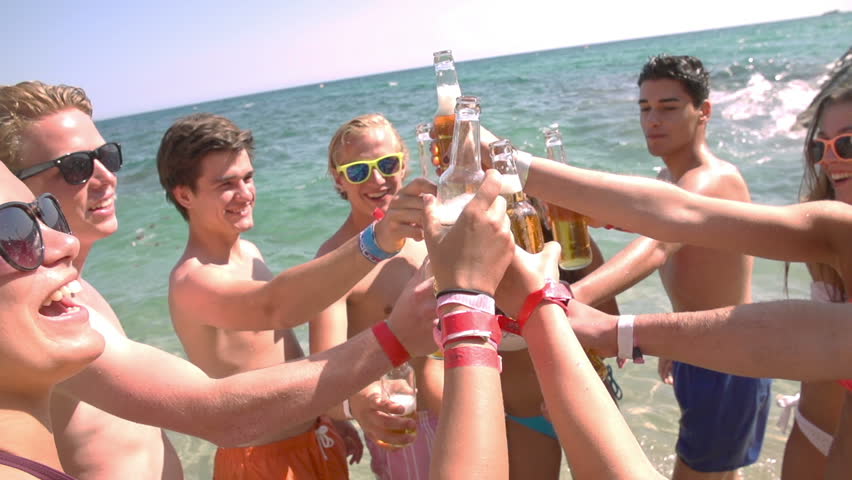 Group of friends cheers with beers at the beach in slow motion | Shutterstock HD Video #7244119
