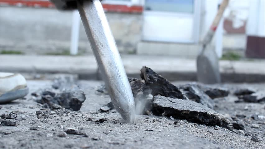 Worker drilling concrete with compressor on the street. Man with the drill breaking up asphalt on the road. Man using a jackhammer. Preparation for paving. Road work. Construction, vibration, close up Royalty-Free Stock Footage #7246795