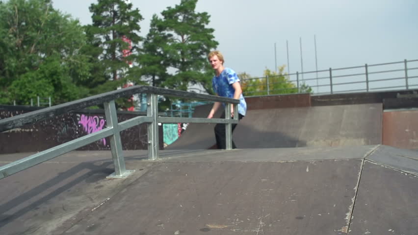 Hipster grinding on skate board deck down the rail