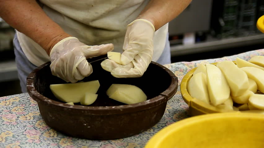 Cutting and peeling potatoes to make pierogis.