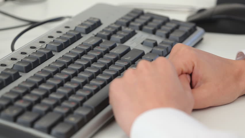 close shot of a female's hands typing on a keyboard 