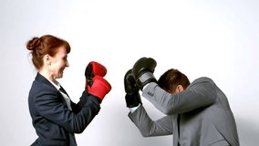 Young businesswoman punching colleague with boxing gloves in slow motion - Powered by Shutterstock - Get 15% off with code: PIKWIZARD15