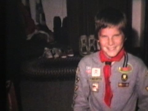 A proud young boy scout shows off his awards after attending a special Cub Scout camp. 