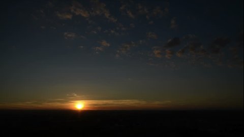 Wide shot time lapse view of sun rising and clouds