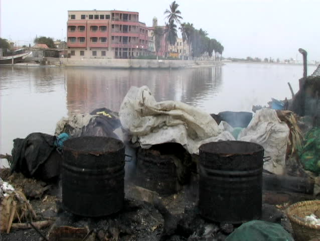 Pots of smoking fish by the river in senegal africa