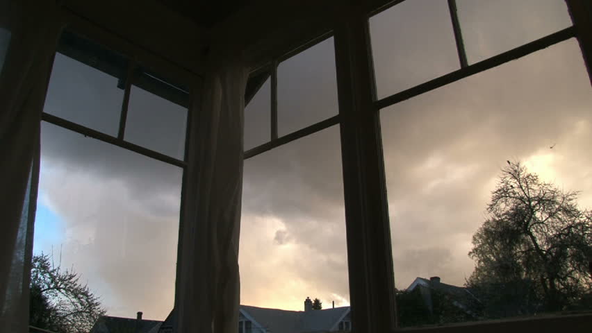 Full sunset time lapse through old windows in house. Rain clouds develop and