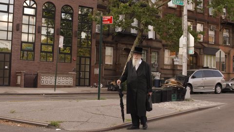 NEW YORK - AUGUST 8, 2014: Orthodox Jew walking in Williamsburg Brooklyn in 4K in New York. Williamsburg is well known for its Hasidic Jewish community.