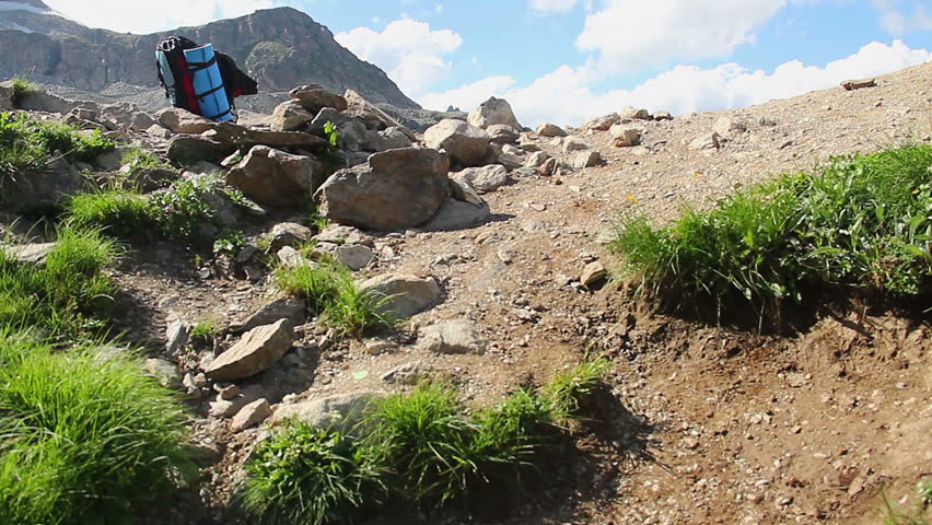 Tourist walking up the mountain to the beautiful blue lake