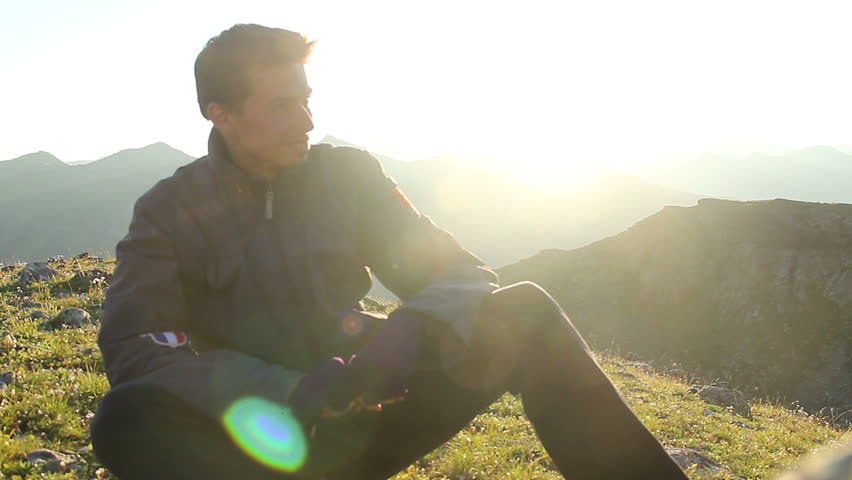 Happy male tourist smiling enjoying beautiful view on mountains