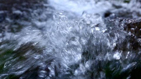 Close up of water stream with white and transparent bubbles.